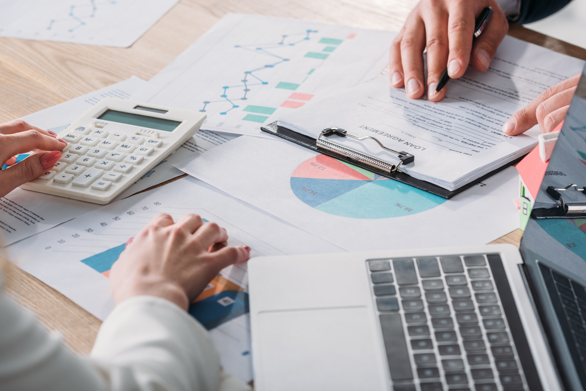 partial-view-of-man-studying-loan-agreement-and-businesswoman-using-calculator-while-sitting-at.jpg partial-view-of-man-studying-loan-agreement-and-businesswoman-using-calculator-while-sitting-at.jpg